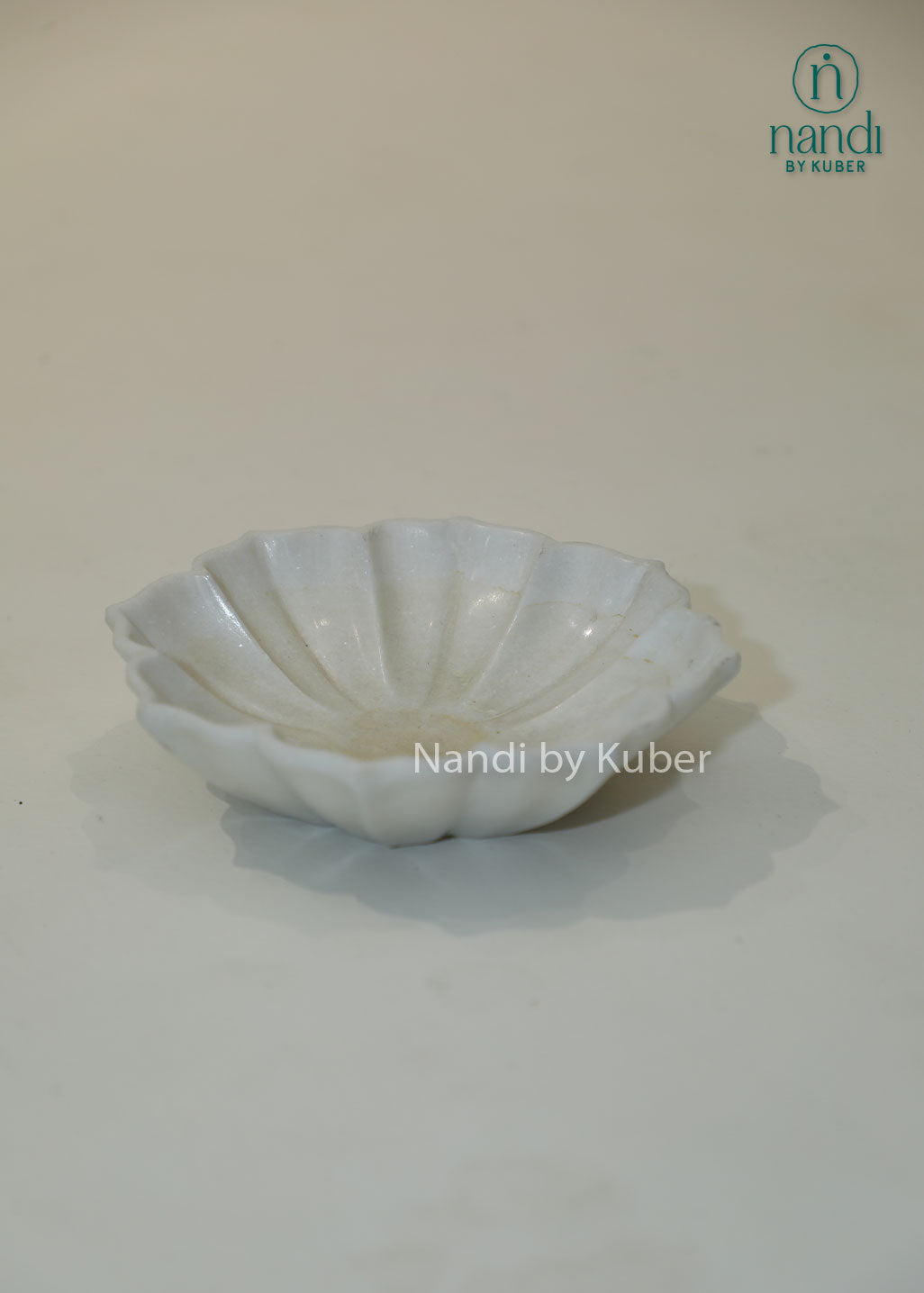 Handcrafted white marble urli bowl with decorative fluted edges and polished finish, ideal for floating flowers, candles, festive décor, centerpieces, and luxury home decoration.