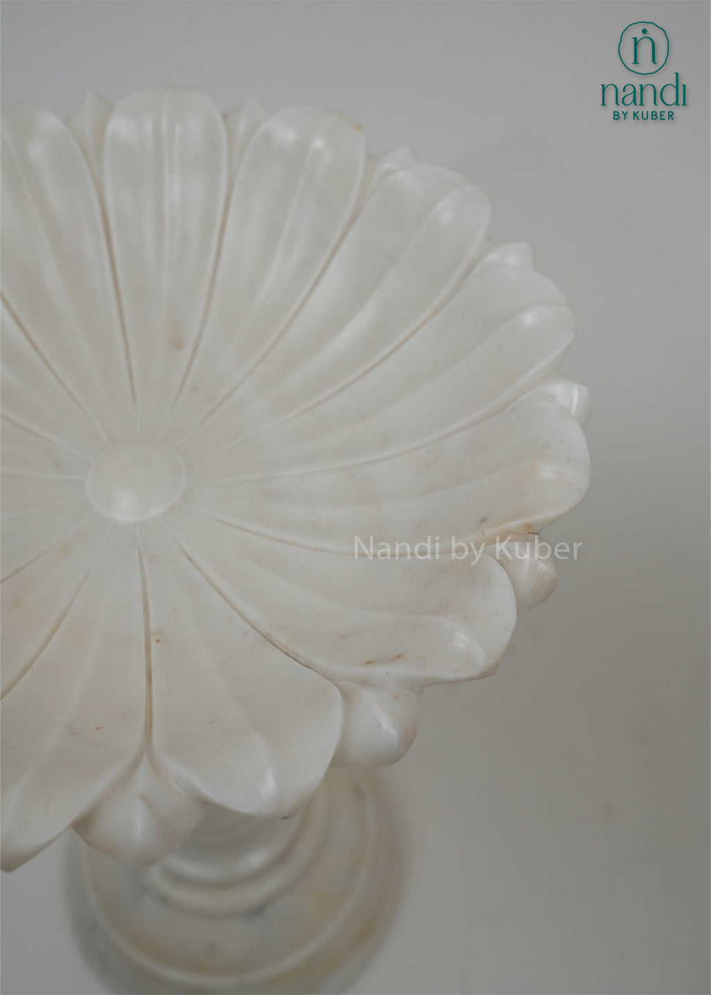 Set of two white marble urli bowls with pedestal stands and floral edges, decorative centerpiece bowls for home décor, festive decoration, weddings, and pooja arrangements.
