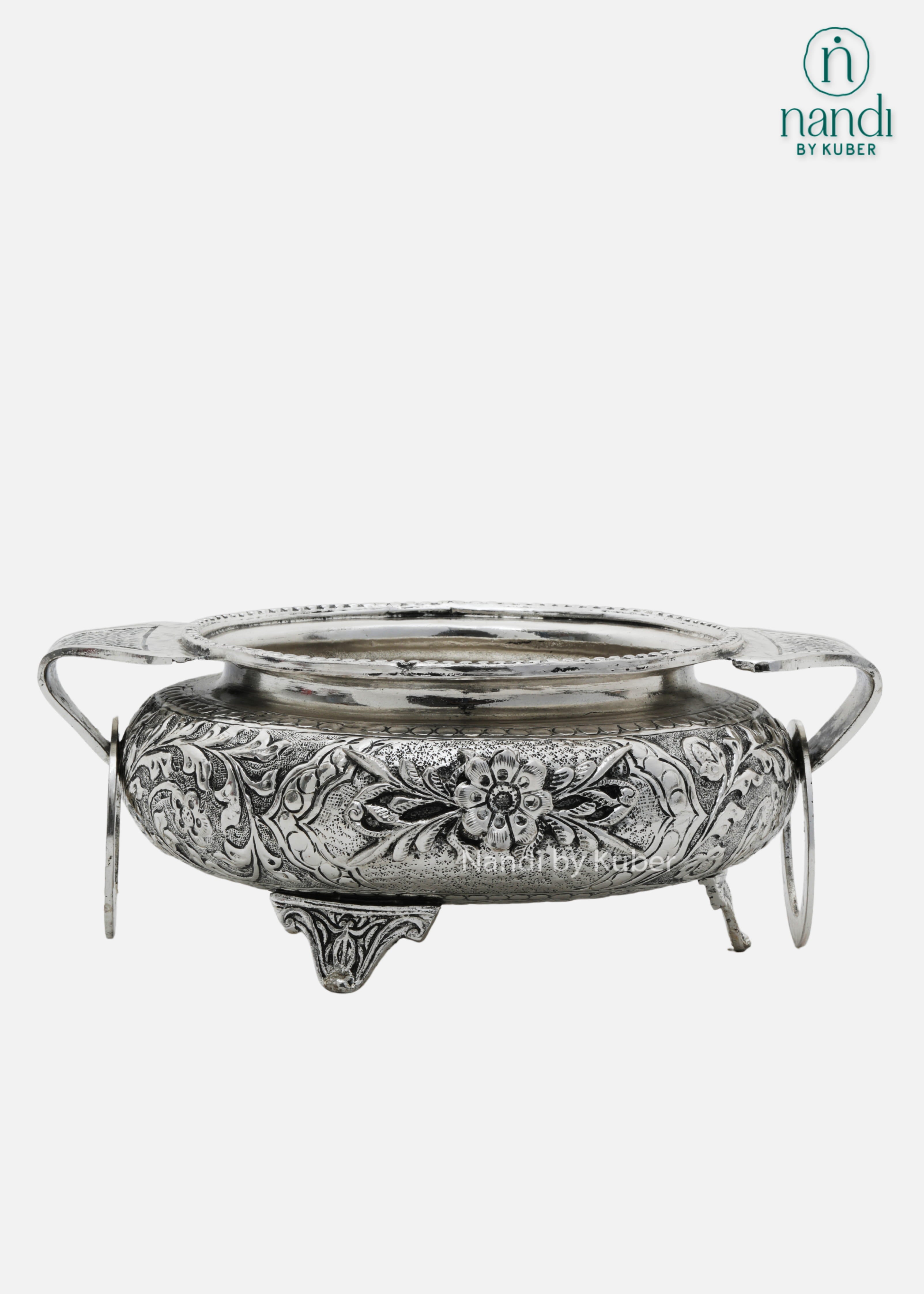 Decorative silver metal serving bowl with handles and intricate floral carving