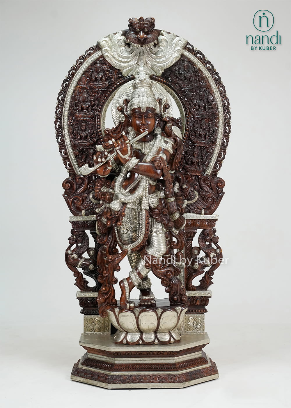 Wood-tone and ivory-finish Lord Krishna statue with ornate carved arch, flute, and decorative pedestal base.