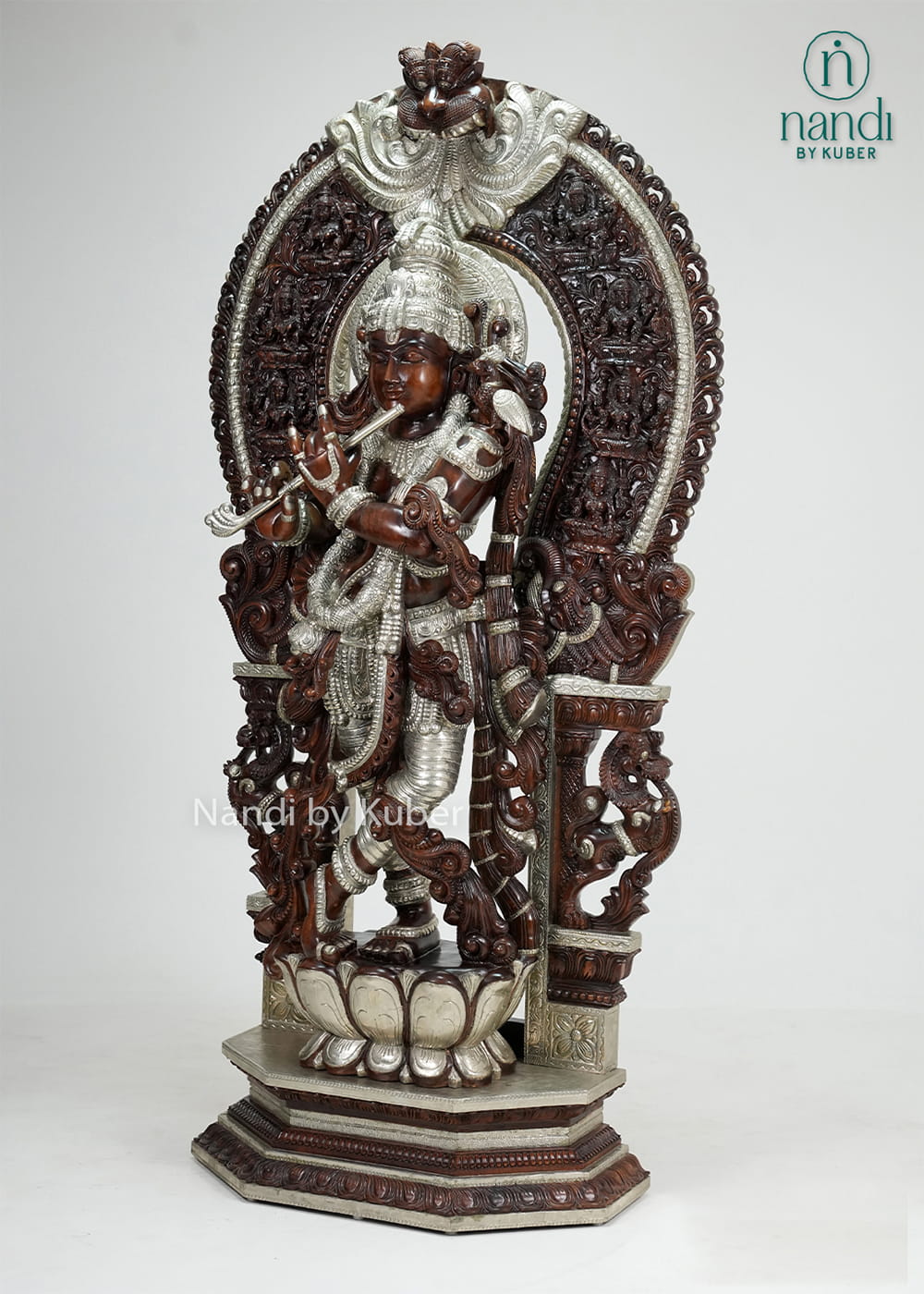 Wood-tone and ivory-finish Lord Krishna statue with ornate carved arch, flute, and decorative pedestal base.