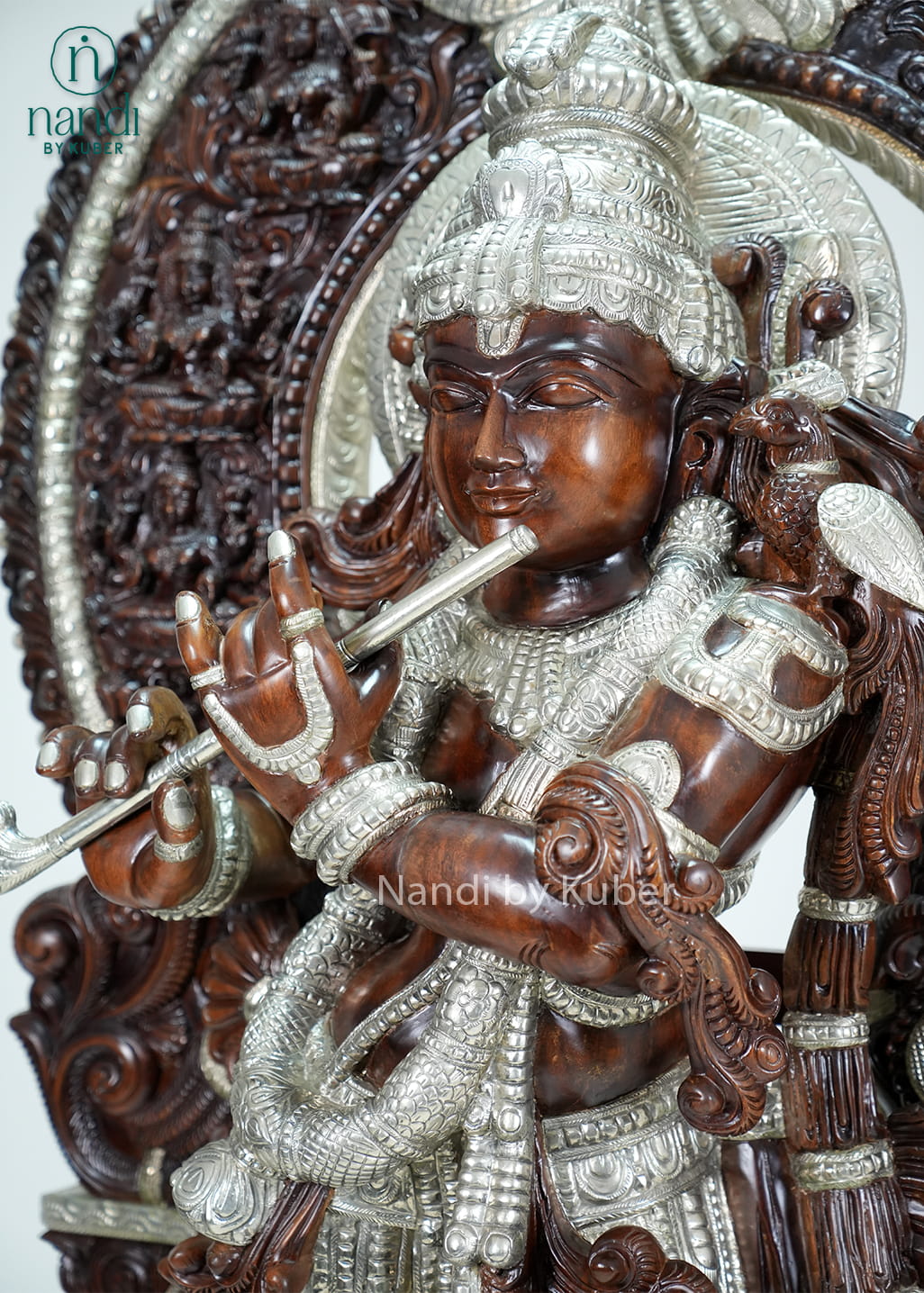 Wood-tone and ivory-finish Lord Krishna statue with ornate carved arch, flute, and decorative pedestal base.