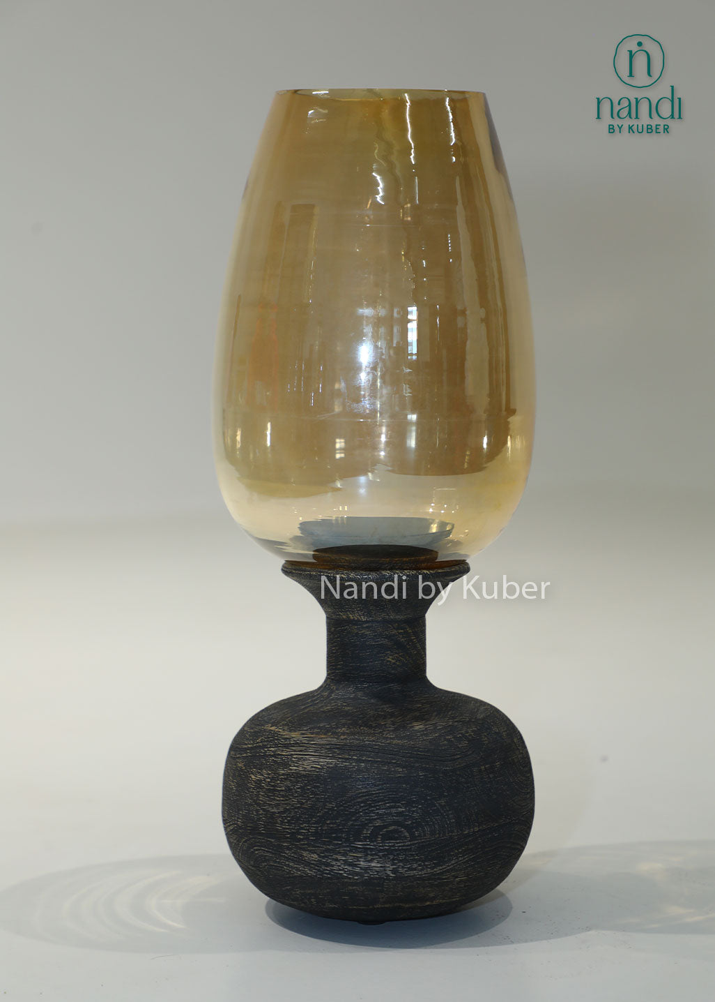 Wooden matka candle holder with amber glass shade, handcrafted decorative candle stand for home décor, table centerpiece, ambient lighting, festive decoration, rustic interiors, and elegant living spaces.