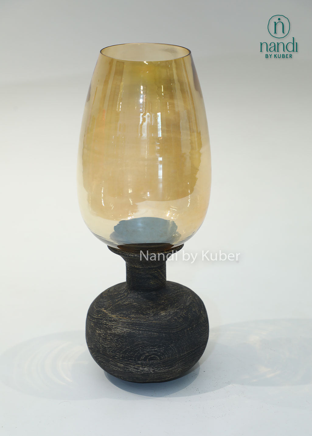 Wooden matka candle holder with amber glass shade, handcrafted decorative candle stand for home décor, table centerpiece, ambient lighting, festive decoration, rustic interiors, and elegant living spaces.