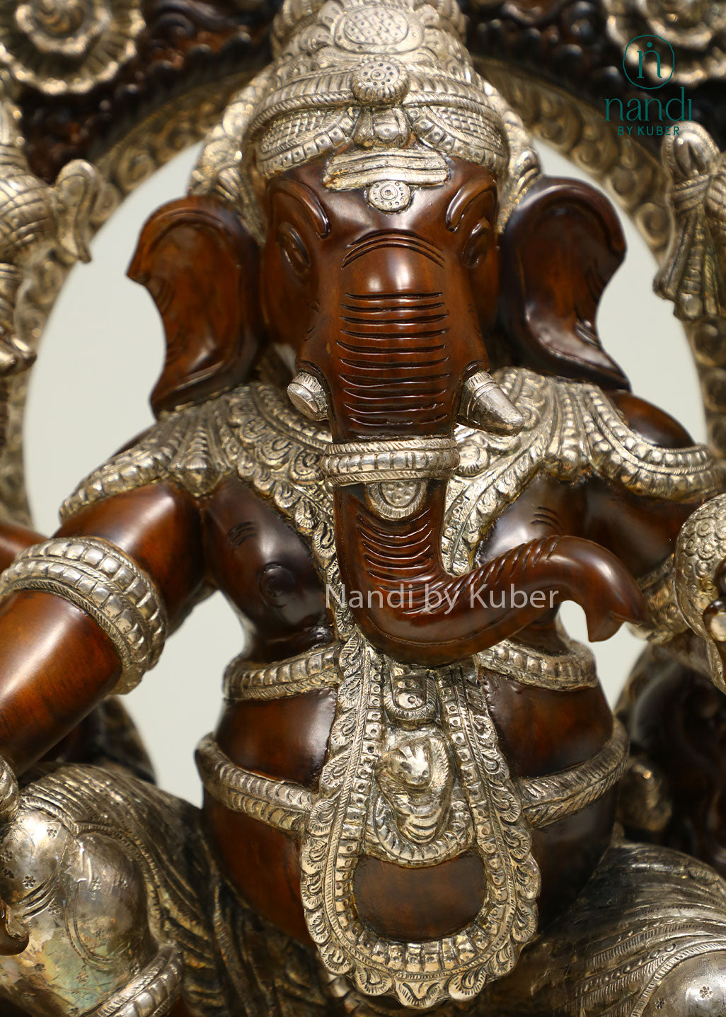 Handcrafted Lord Ganesha statue seated on an ornate royal throne with elegant silver detailing, perfect for devotional décor and spiritual spaces.