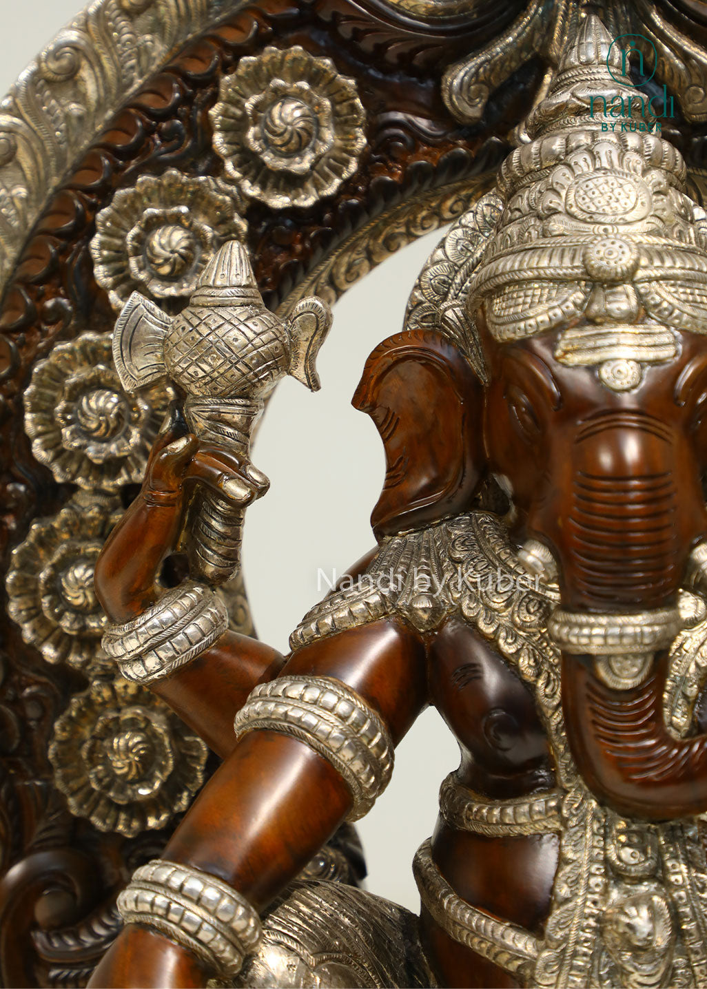 Handcrafted Lord Ganesha statue seated on an ornate royal throne with elegant silver detailing, perfect for devotional décor and spiritual spaces.
