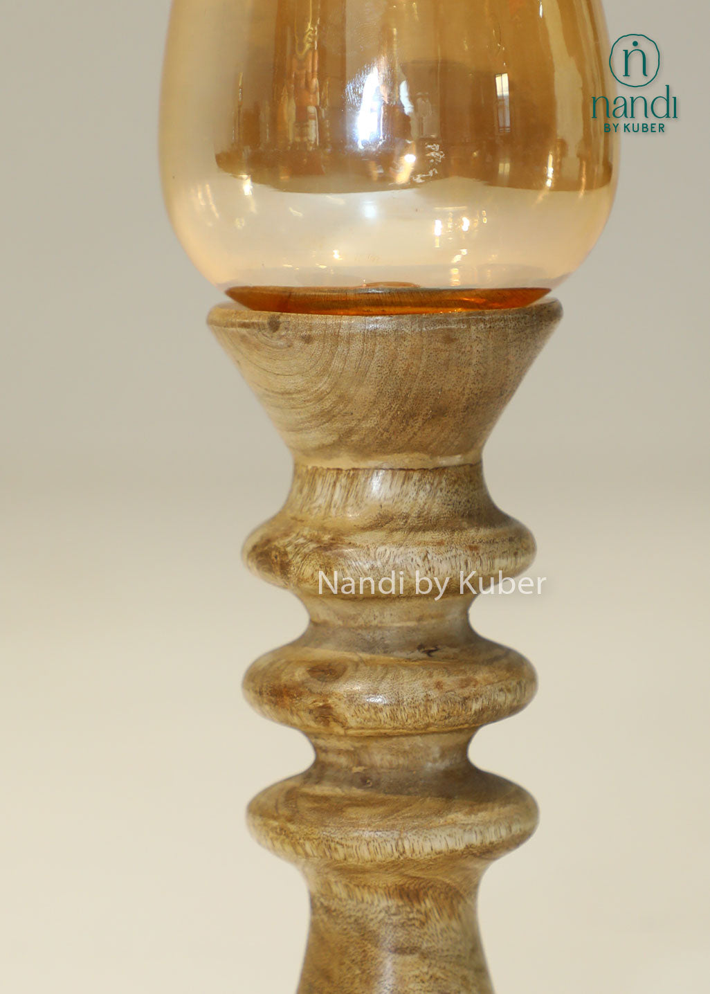 Decorative wooden candle stand with a spiral-turned base and amber glass shade, adding warmth and elegance to any interior setting.